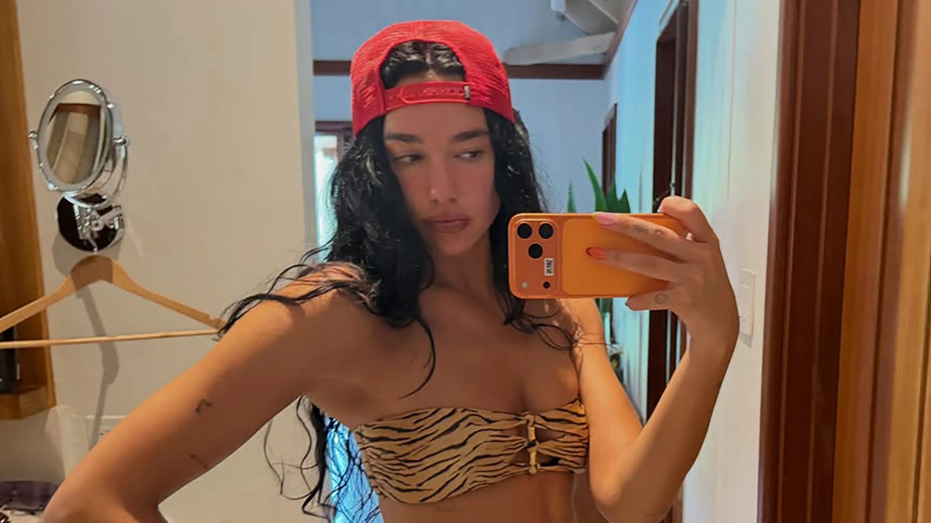Dua Lipa shows off her bronzed body in a tiny bikini as she sunbathes on holiday with pals