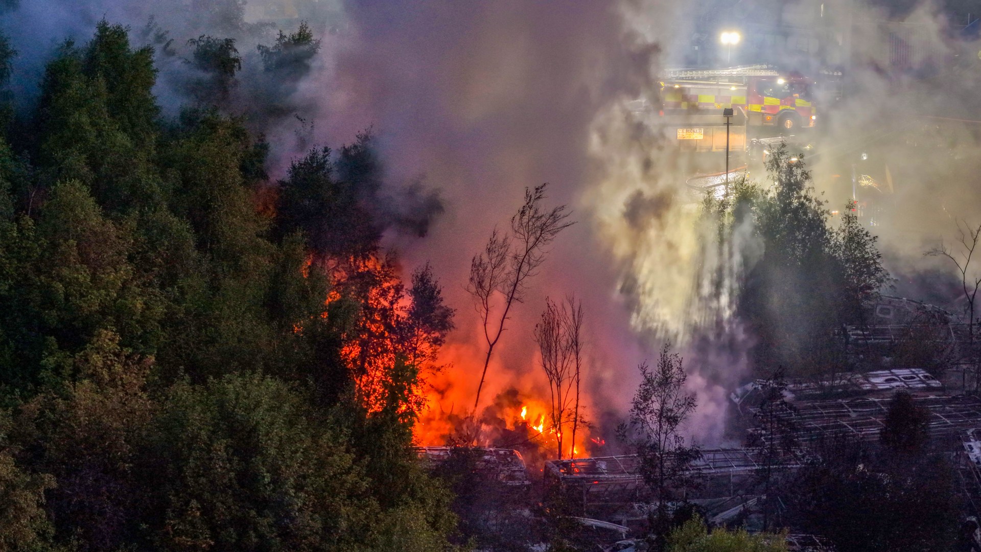 Huge blaze erupts at scrapyard with plumes of black smoke billowing across the sky