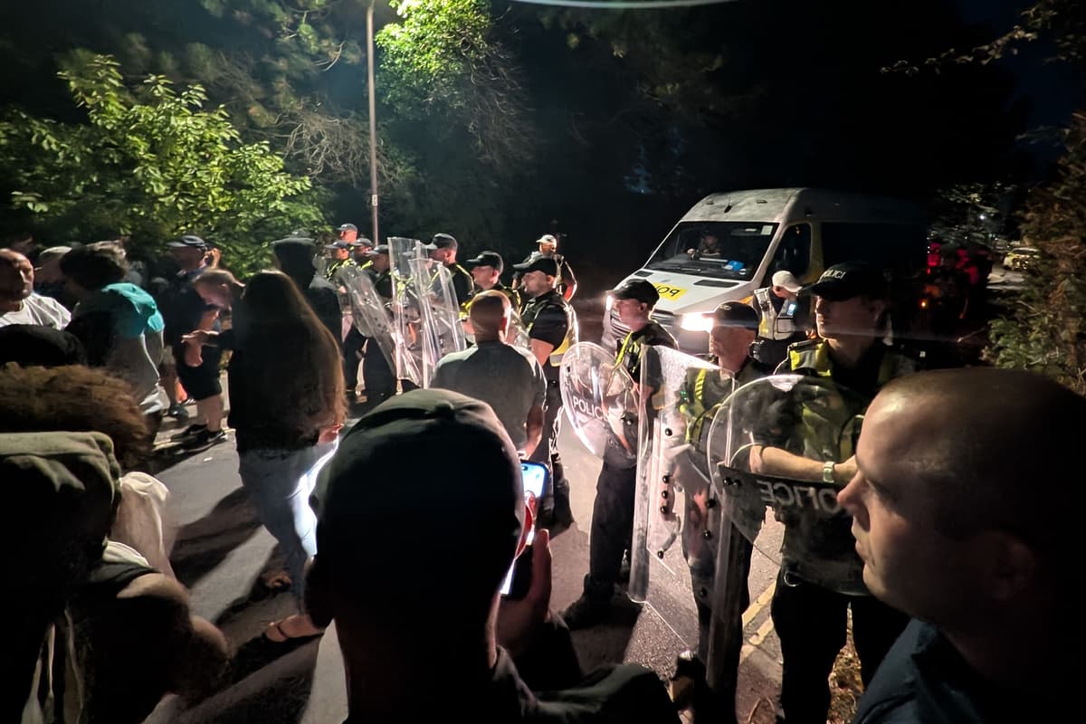 Hundreds of protesters in standoff with police after migrant boat arrives