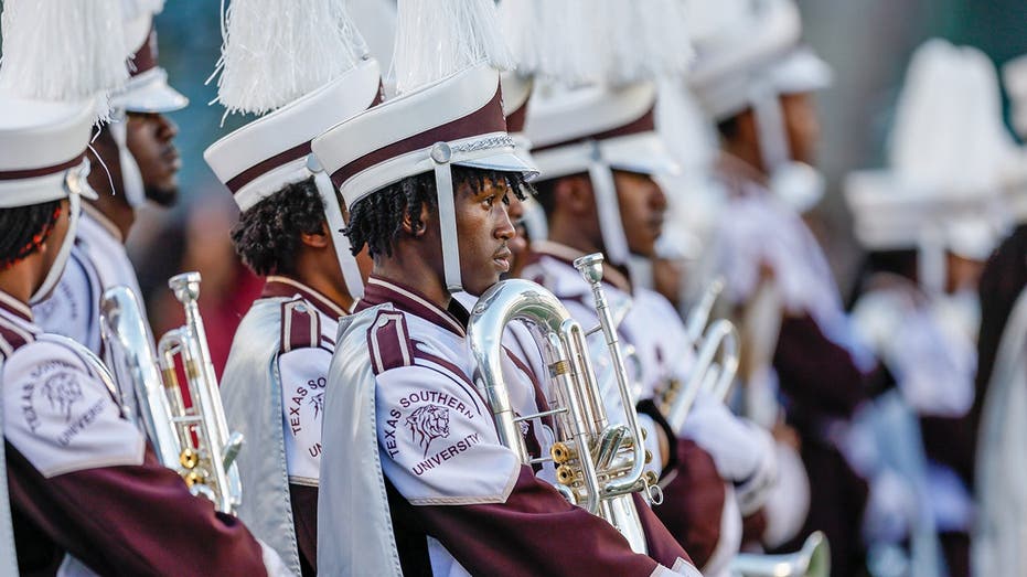 Marching band tuba player unleashes punches on man at college football game without missing a beat