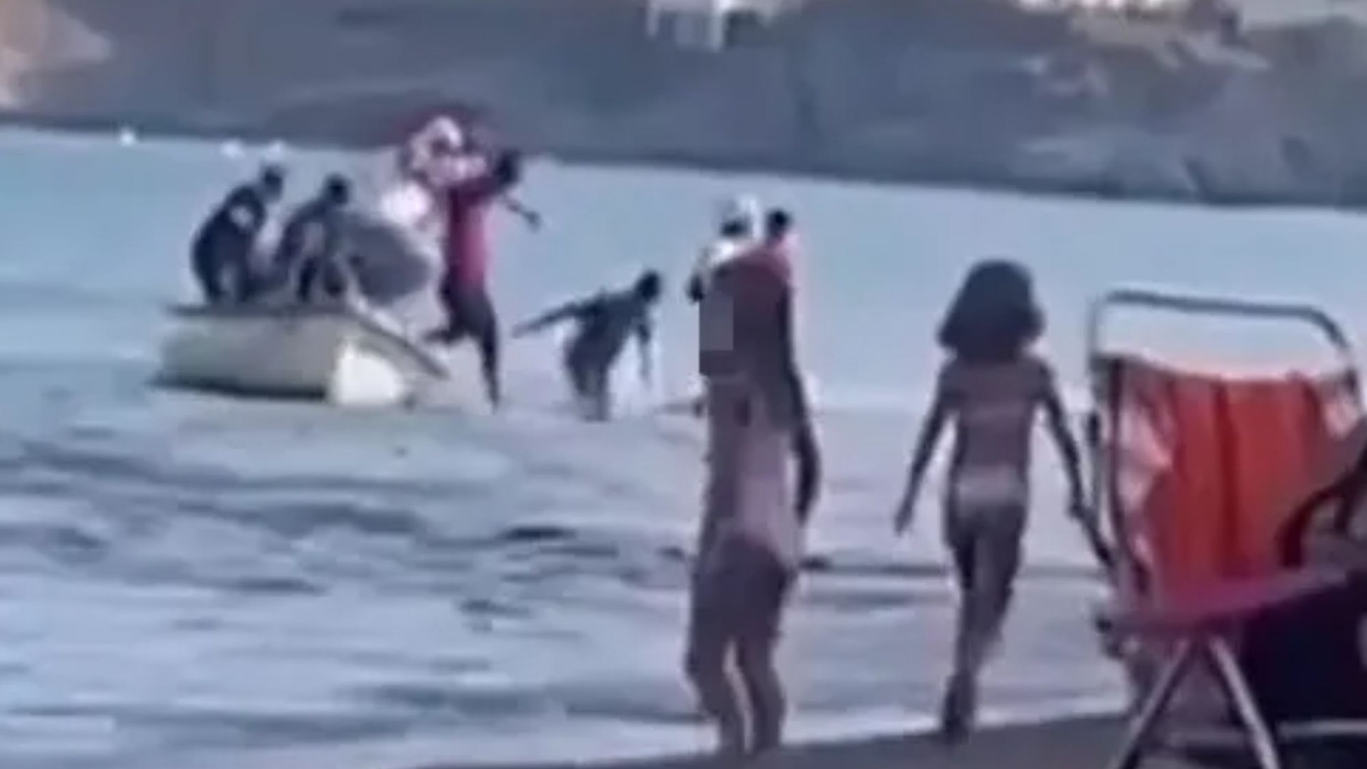 Migrant ‘taxi boat’ arrives at popular Spanish beach before men jump off and wade to shore in front of stunned tourists