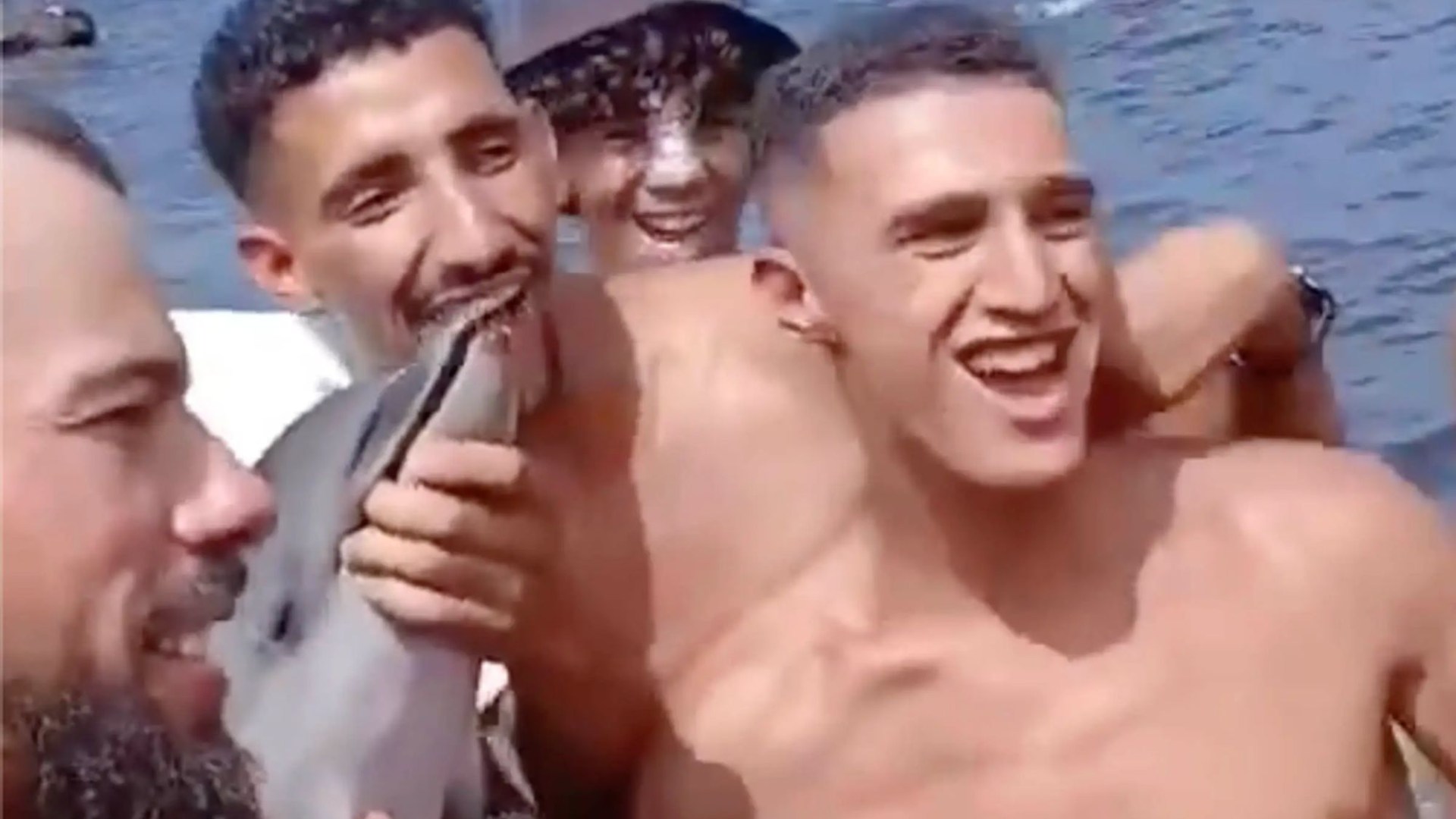 Sickening new vid shows migrants posing for selfies with baby dolphin after it was dragged from Ceuta sea sparking fury